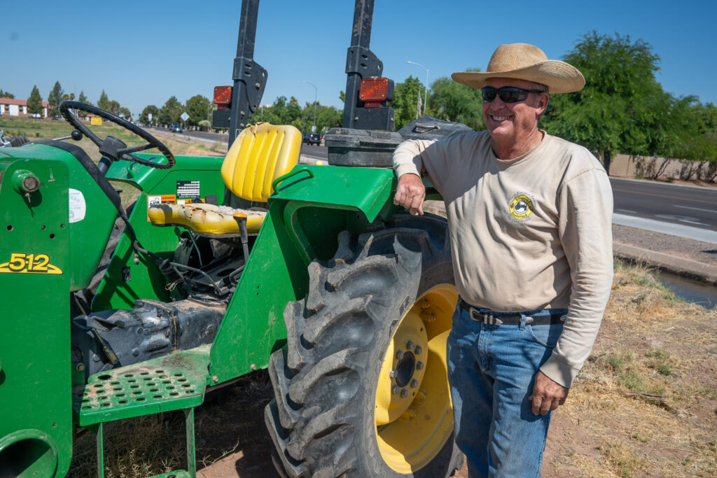Freeman standing and smiling by his tractor