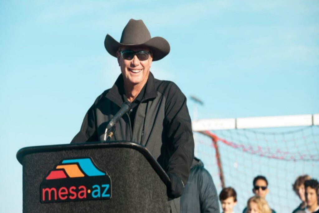 Mark Freeman smiling in front of a podium giving a speech.